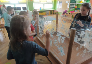 Dzieci malują na folii zimowe pejzaże.
